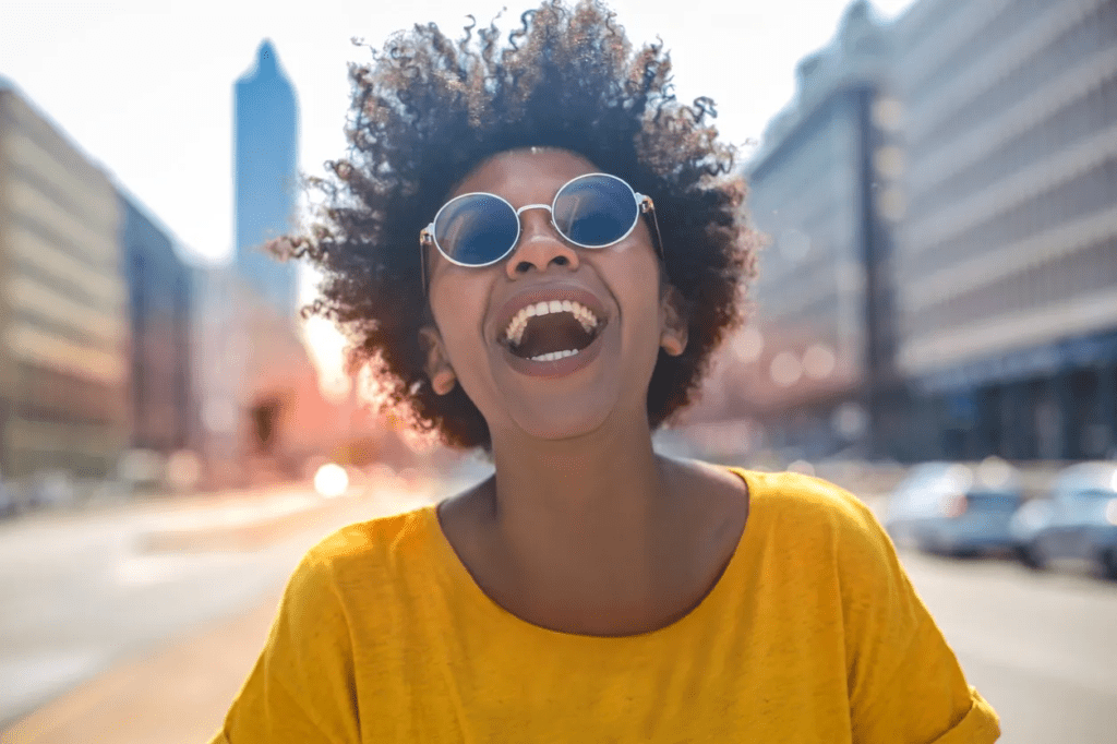 A woman with sunglasses on and smiling.